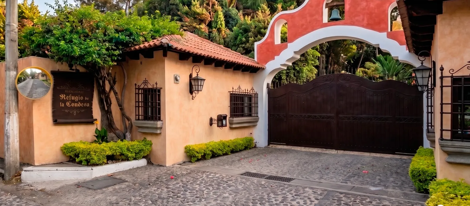 Entrada principal del residencial con su arco de campana y portón de hierro